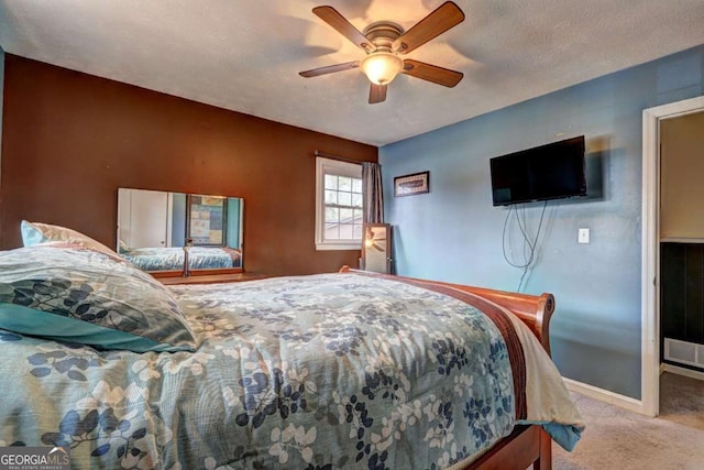 bedroom with light carpet, a ceiling fan, baseboards, and a textured ceiling