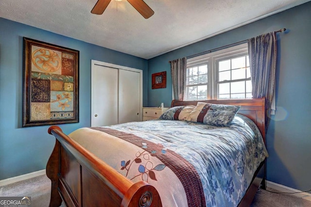 carpeted bedroom featuring a ceiling fan, a textured ceiling, baseboards, and a closet