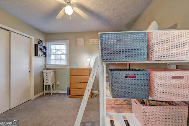 bedroom with light carpet, a textured ceiling, a closet, and baseboards