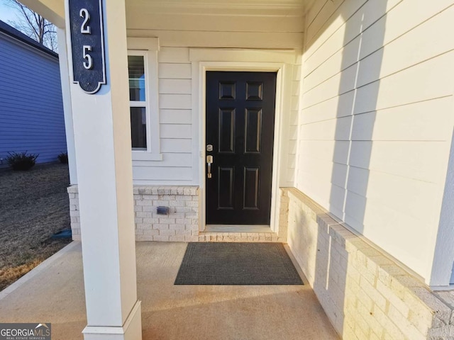 doorway to property featuring brick siding