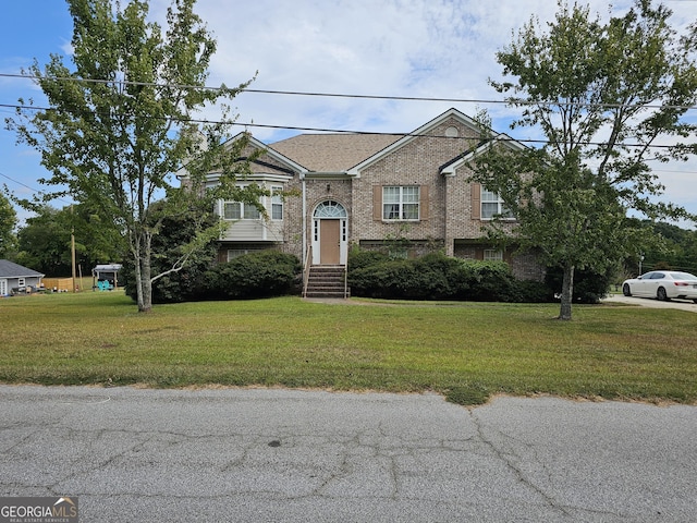 split foyer home featuring brick siding and a front yard