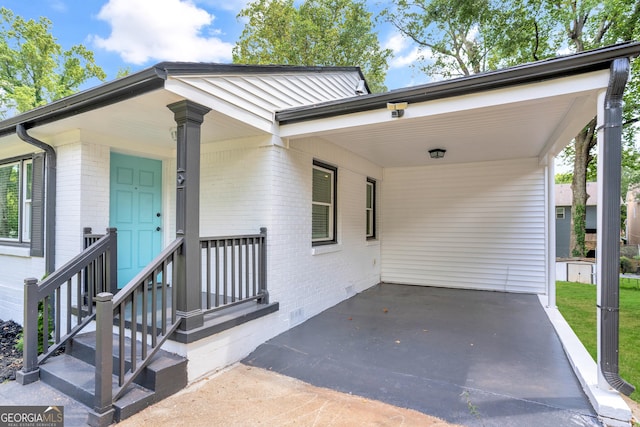 view of front of property featuring an attached carport, brick siding, and driveway