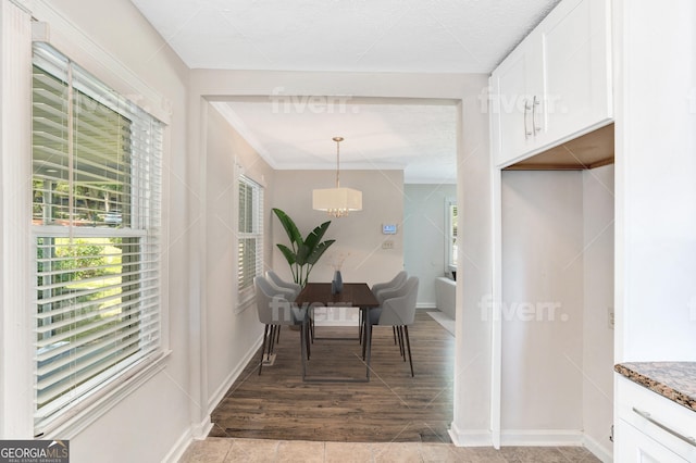 dining space featuring a chandelier, crown molding, and baseboards