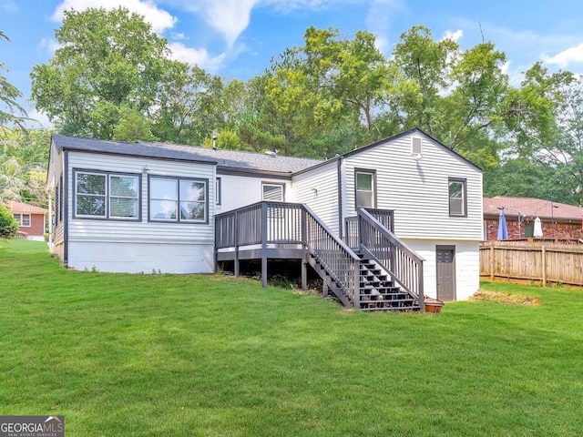 rear view of property with fence, stairway, a deck, and a lawn