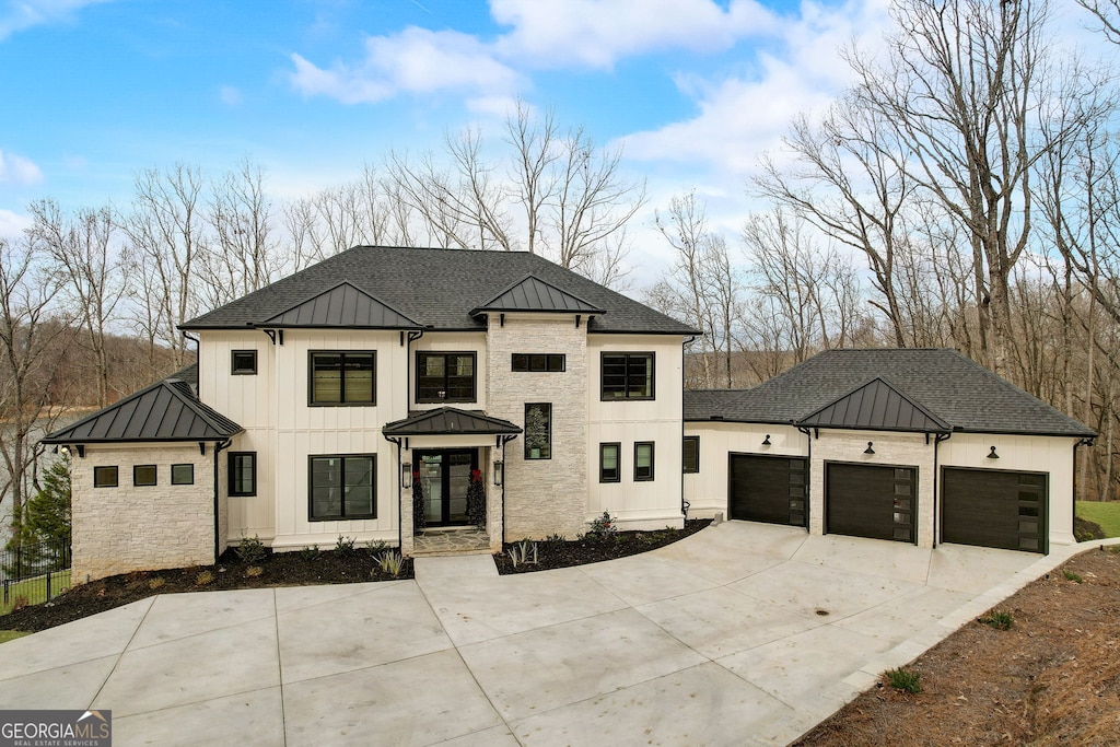 modern inspired farmhouse featuring driveway, metal roof, roof with shingles, an attached garage, and a standing seam roof