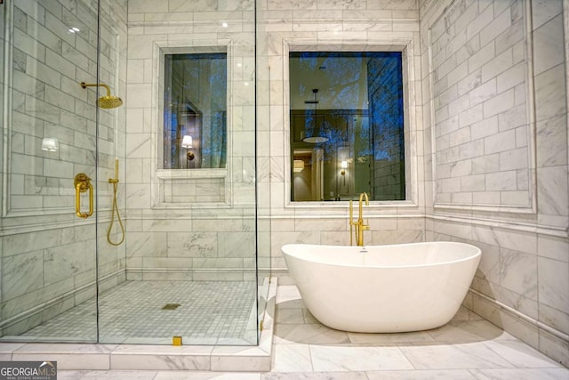 full bath featuring a shower stall, tile walls, and a freestanding bath