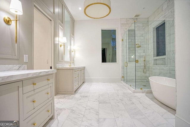 bathroom featuring marble finish floor, a freestanding bath, vanity, a shower stall, and baseboards