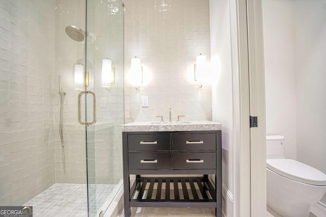 full bathroom with a stall shower, vanity, toilet, and tile patterned floors