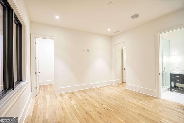 empty room with light wood-style floors, recessed lighting, and baseboards