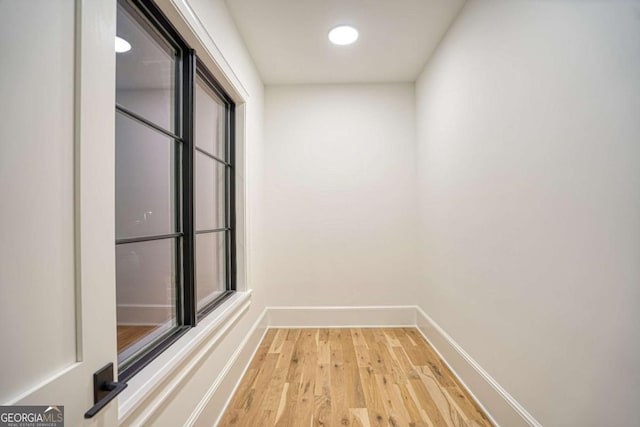 hallway with light wood finished floors and baseboards