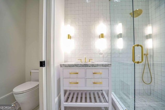 bathroom with a stall shower, vanity, and toilet