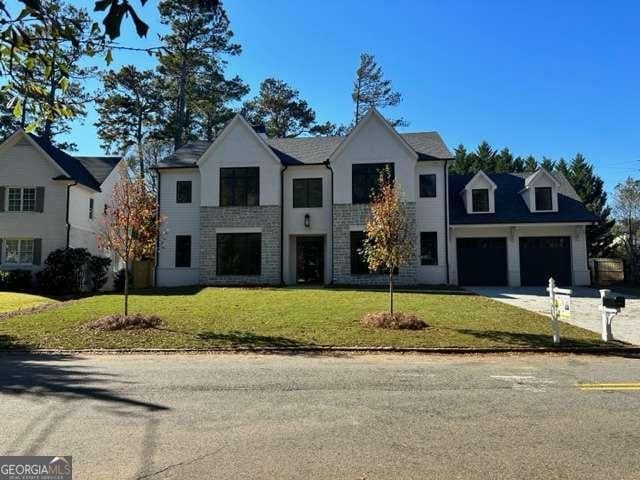 view of front of home featuring a garage, driveway, and a front lawn