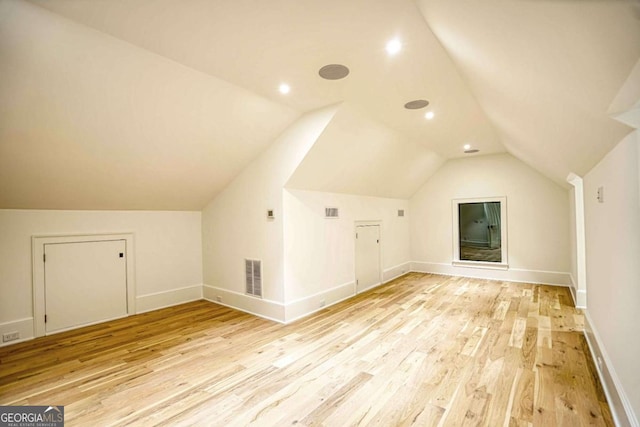 bonus room featuring light wood-style floors, lofted ceiling, visible vents, and baseboards