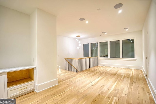 spare room featuring recessed lighting, light wood-style flooring, and baseboards