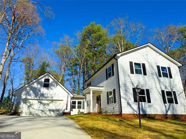 view of front of home with a garage, concrete driveway, and a front yard