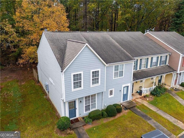 view of front of house featuring a front yard, roof with shingles, and entry steps