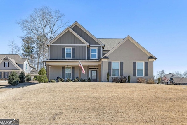 view of front facade with a front lawn, board and batten siding, and brick siding