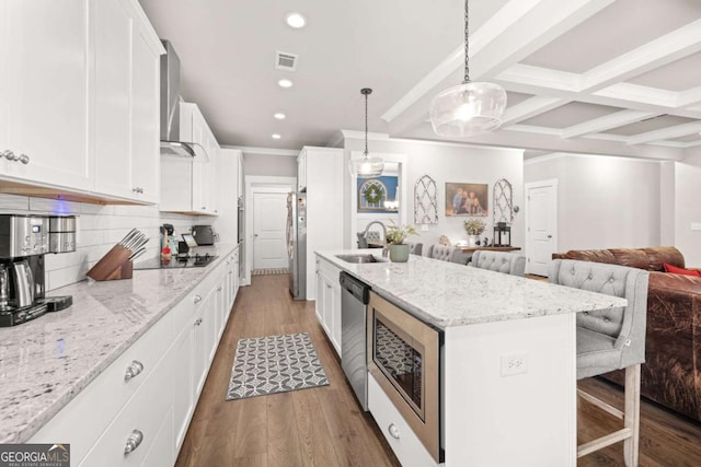 kitchen with stainless steel appliances, white cabinetry, open floor plan, a center island with sink, and pendant lighting