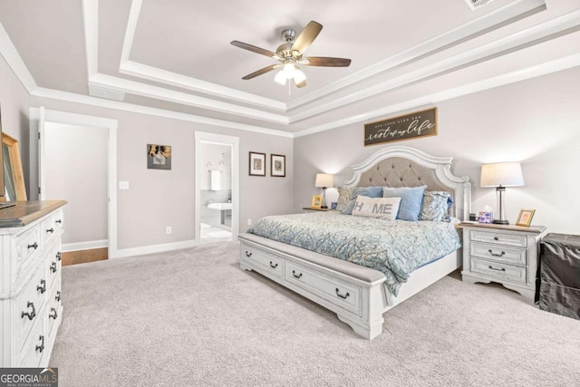 bedroom featuring crown molding, a tray ceiling, baseboards, and light colored carpet