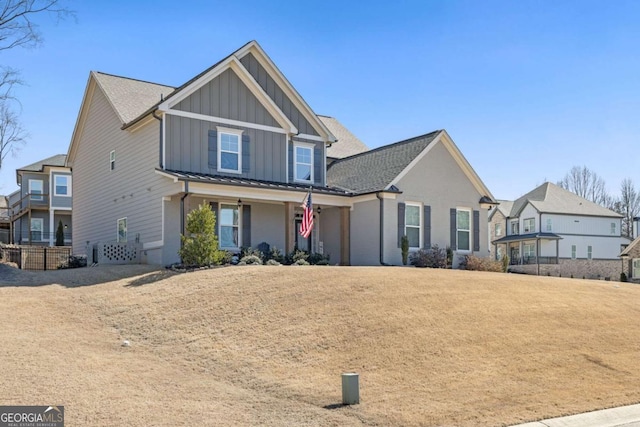 view of front of house with a standing seam roof, board and batten siding, and a front yard