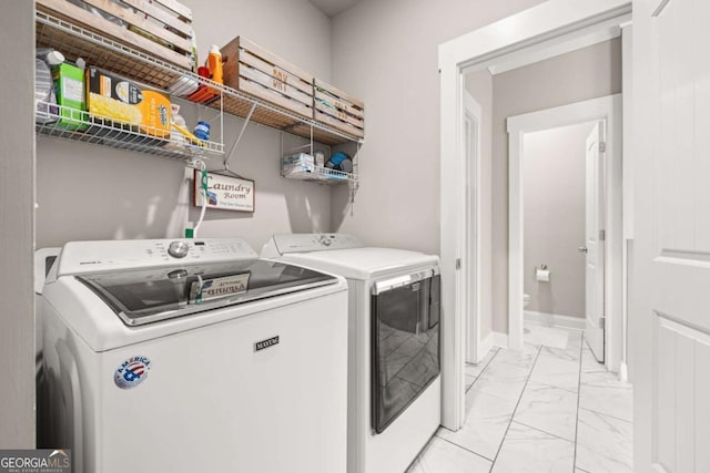 laundry area with marble finish floor, washer and clothes dryer, baseboards, and laundry area