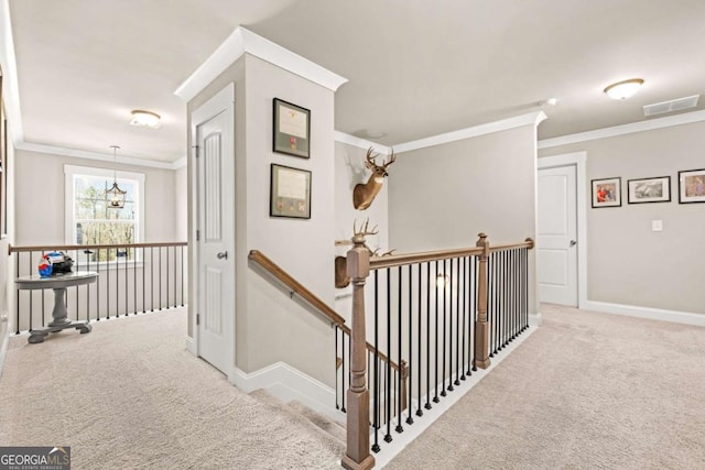 corridor with light carpet, visible vents, baseboards, an upstairs landing, and crown molding