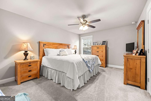 bedroom featuring light carpet, baseboards, and a ceiling fan