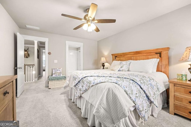 bedroom featuring a ceiling fan, light carpet, and visible vents