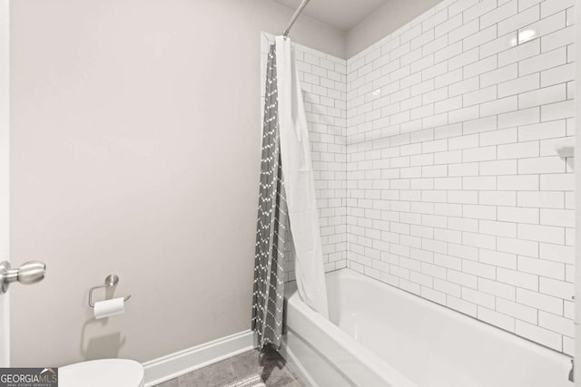 full bathroom with shower / bath combination with curtain, toilet, and baseboards