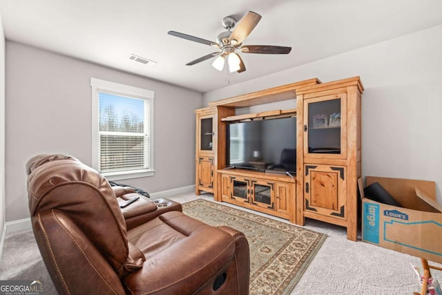 living area featuring visible vents, ceiling fan, light carpet, and baseboards