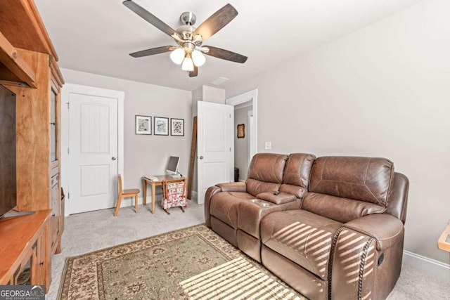 living area with light colored carpet, ceiling fan, and baseboards