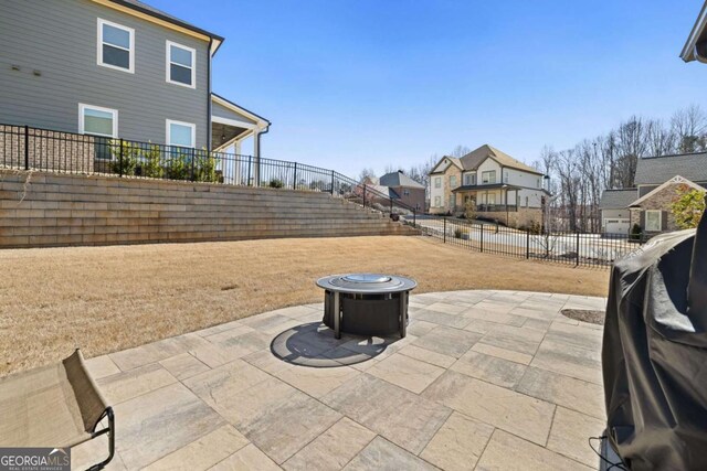 view of patio with an outdoor fire pit, a residential view, grilling area, and a fenced backyard