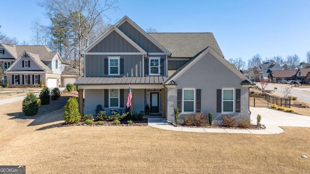 craftsman inspired home with a front yard, a porch, board and batten siding, and brick siding