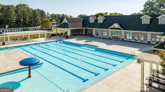 pool with a patio area and fence