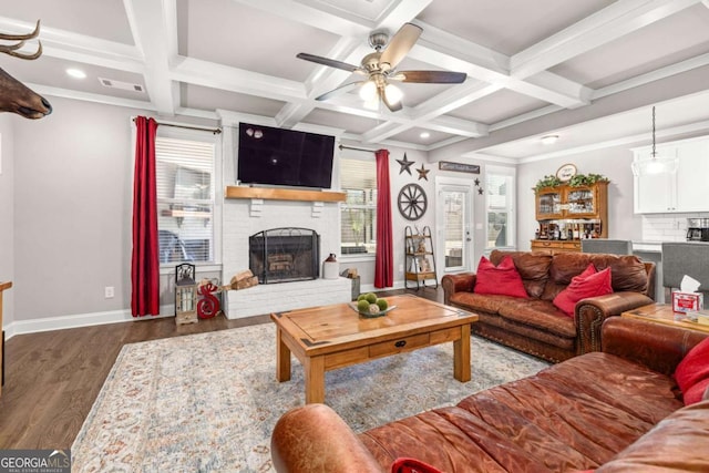 living area with a wealth of natural light, a fireplace, baseboards, and wood finished floors