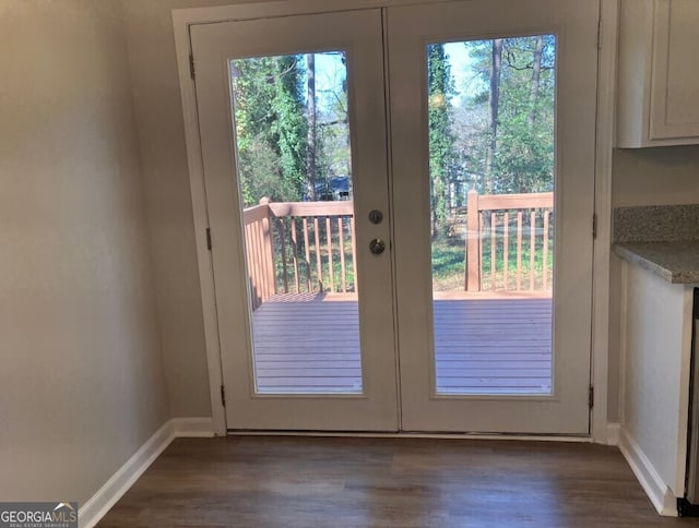 doorway featuring french doors, dark wood-type flooring, and baseboards