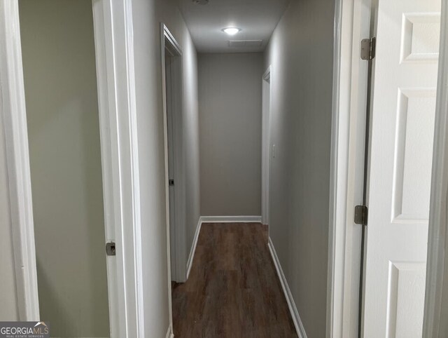 hallway with baseboards and dark wood-type flooring