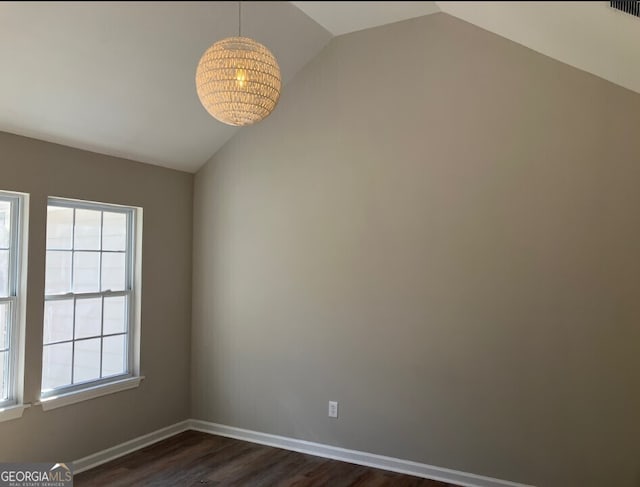 unfurnished room featuring visible vents, baseboards, vaulted ceiling, and dark wood-style flooring