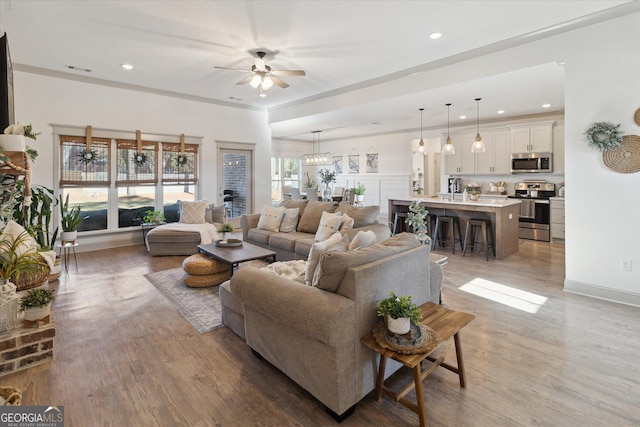 living area featuring ceiling fan, visible vents, wood finished floors, and recessed lighting