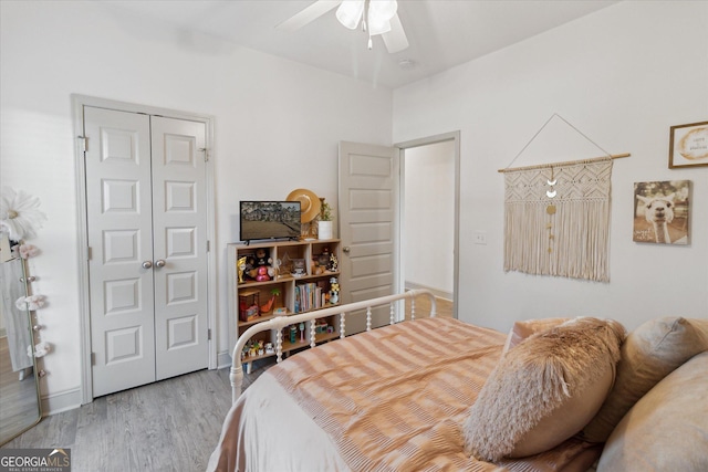 bedroom featuring light wood-type flooring, a closet, and a ceiling fan