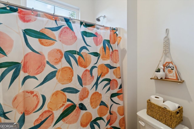 bathroom featuring a shower with curtain and toilet