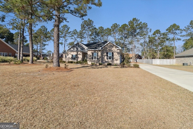 view of front of home featuring fence, concrete driveway, and a front yard