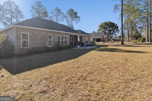 back of property with brick siding and a lawn