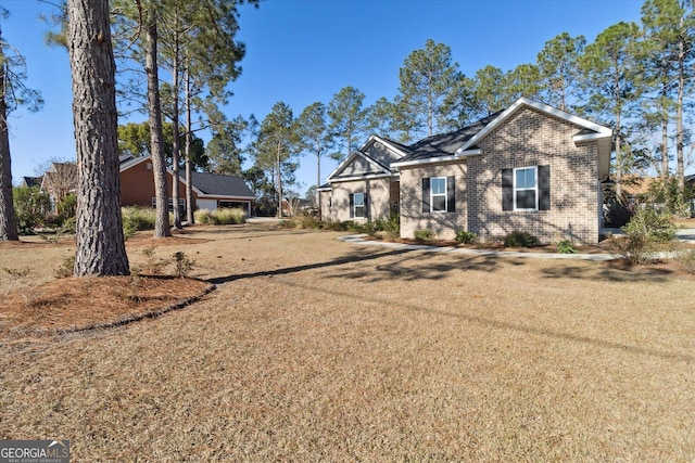 view of front facade featuring brick siding and a front lawn