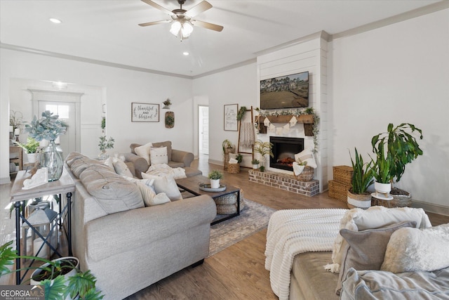 living room featuring baseboards, ceiling fan, wood finished floors, a fireplace, and recessed lighting