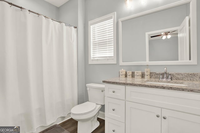 full bath with toilet, ceiling fan, wood finished floors, and vanity