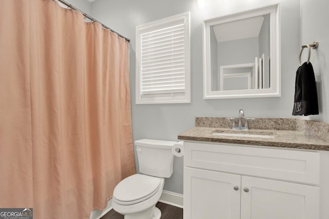 bathroom featuring wood finished floors, vanity, and toilet