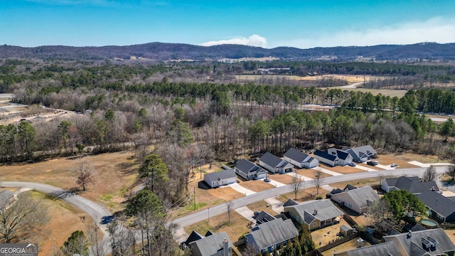 drone / aerial view featuring a residential view, a mountain view, and a wooded view