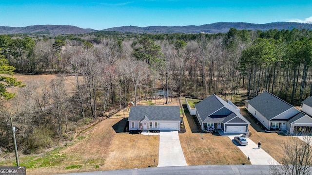 drone / aerial view with a mountain view and a wooded view