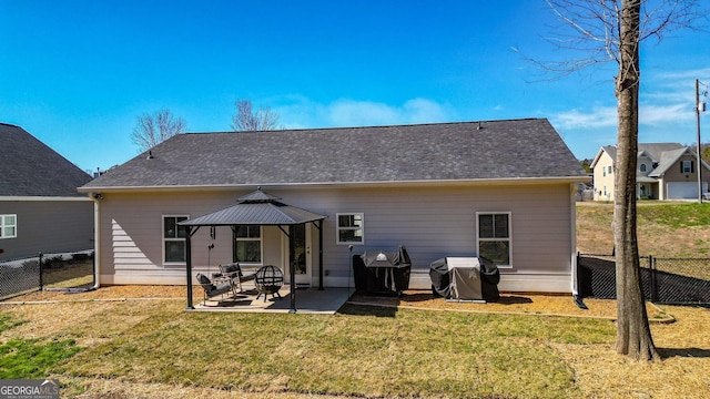 rear view of house featuring a patio area, a yard, a gazebo, and fence